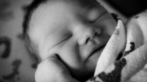 Newborn baby with a heartwarming smile on their face, radiating pure joy.
